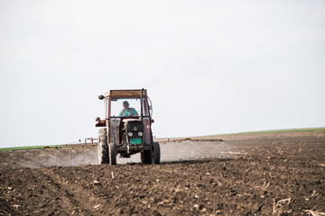 Obraz premium tractor spraying sunflower field before sprouting. treating the soil with chemistry.