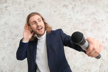 Naklejka premium Young male singer on light background