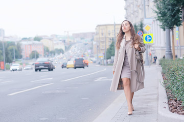 business lady stands road, cars, traffic, urban style, travel in the city, woman and cars