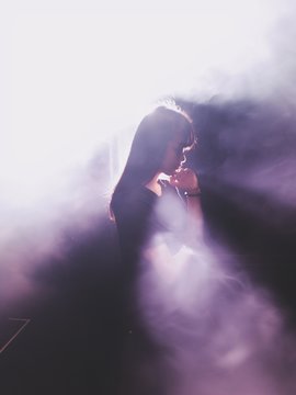 Side View Of Thoughtful Woman Standing Amidst Purple Smoke