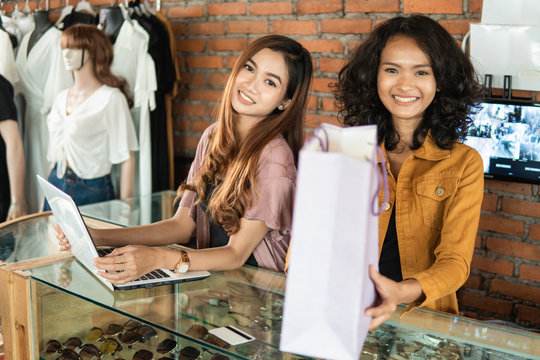 woman shopping at boutique store in the mall. shopping woman take paper bag