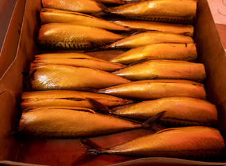Hot smoked mackerel in a box. Selling fish in the market. Day. Georgia.