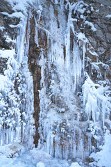 Fototapeta na wymiar Icicles on the rock. Frozen waterfall in winter.