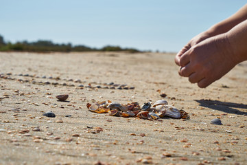 Girl lays out a drawing in the sand.