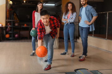 Friends playing bowling in club