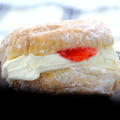 German Berliner doughnut with raspberry jam filling on background. Macro image of a donut with jam. Homemade dessert. Famous sweets.
