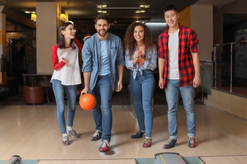 Fototapeta na wymiar Friends playing bowling in club