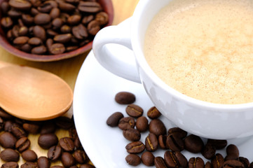 Coffee cup on wooden kitchen table. Top view with morning sunlight