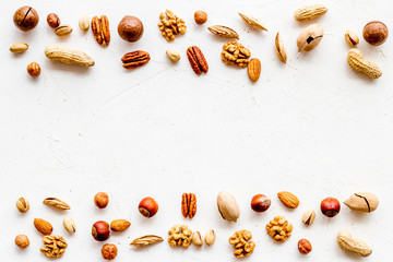 Nuts background - healthy snacks concept - on white table top-down frame copy space