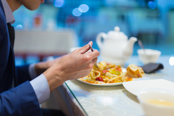 Man eating noodles in a cafe during lunch
