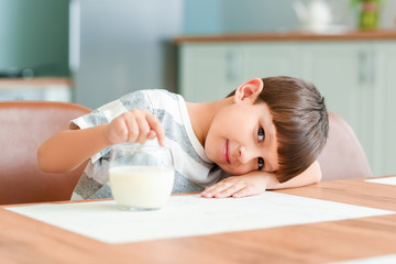 Obraz na płótnie Canvas Little boy with milk in kitchen