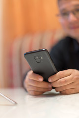 A man sits in a cafe and reads SMS