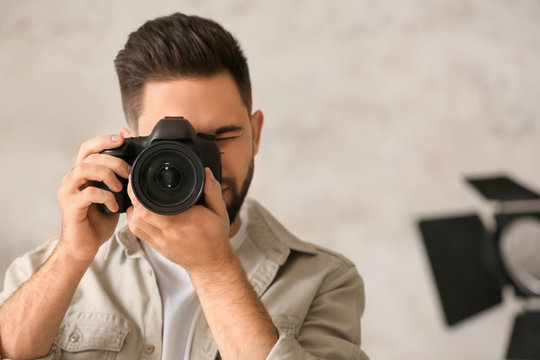 Male photographer with professional camera in studio