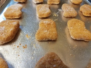 Fototapeta na wymiar frozen chicken nuggets on foil on tray