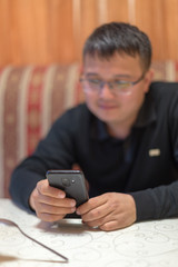 A man sits in a cafe and reads SMS