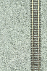 Fine grey gravel background used as track ballast for model railways with section of track
