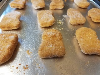 Fototapeta na wymiar frozen chicken nuggets on foil on tray