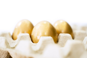 Golden eggs on the carton in the studio