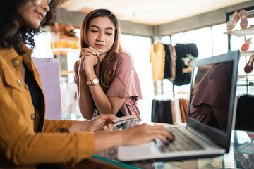 woman shopping at boutique store in the mall. shopping woman take paper bag
