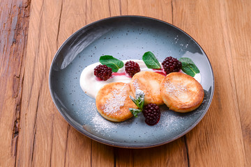 Tasty sweet potato pancakes with sauce served on a plate over dark rustic wooden background. Banner with copy space.