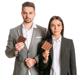 Beautiful young couple with tasty chocolate on white background