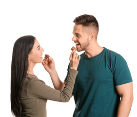 Beautiful young couple with tasty chocolate on white background
