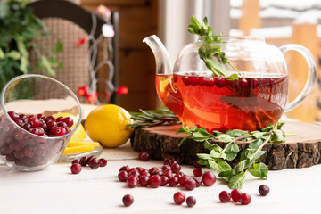 Glass teapot with fruit and herbs for healthy eating on a wooden table