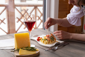 Pasta with cheese and greens on a wooden background by the window