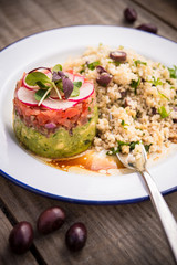 A plate with risotto, rice and salad next two group of olives on a wooden table