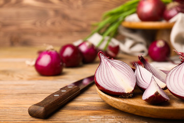 Plate with pieces of fresh raw onion on wooden background