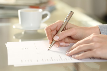Woman hand filling out checkbox form at home
