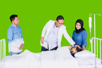 Obraz premium Pediatrician checking boy in studio with parents