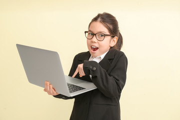 Shocked little businesswoman with laptop on color background