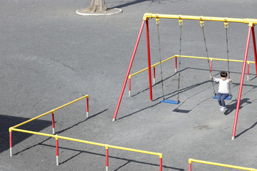 Naklejka premium ブランコで遊ぶ幼児(5歳児)