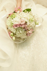 Bride in wedding dress holding flower bouquet 