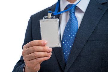 Businessman in suit wearing a blank ID tag or name card on a lanyard at an exhibition or conference.