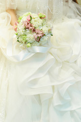 Bride in wedding dress holding flower bouquet 