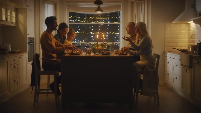 Happy Family Celebrating together, Sitting at the Table Eating Delicious Dinner Meal. Little Child, Young Husband, Wife, Grandfather and Grandmother, Telling Stories, Joking, Having Fun, Being Joyful