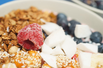 Handmade Bowl healthy tasty breakfast of yogurt, smoothie with granola, nuts, bananas and berries