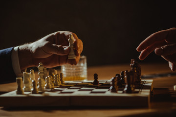 Close up of hands of men playing chess.	