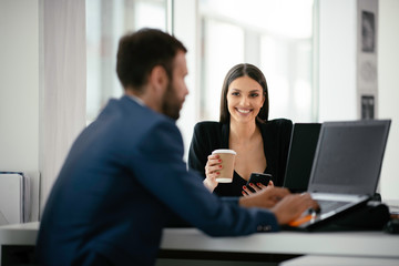 Colleagues working together at the office. Businessman and businesswoman preparing for the meeting.	