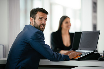 Colleagues working together at the office. Businessman and businesswoman preparing for the meeting.	