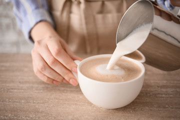 Barista preparing tasty cappuccino in cafe, closeup