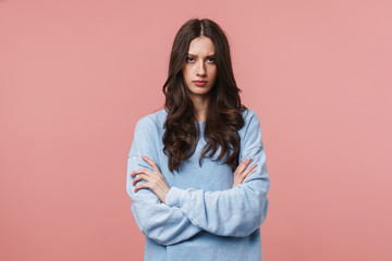 Image of displeased woman frowning and standing with arms crossed