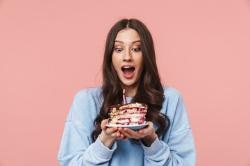 Image of attractive young woman making wish while holding birthday cake