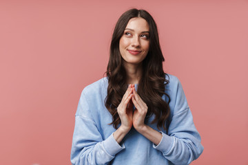 Image of attractive young woman smiling and planning something cunning