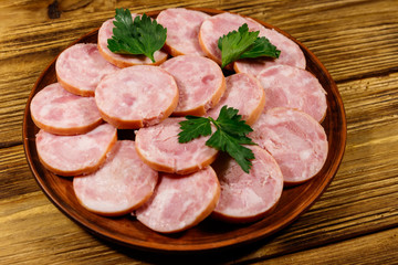 Ham sausage on a plate on wooden table