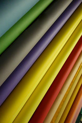 Many rolls of colored paper in red, yellow, purple, orange 