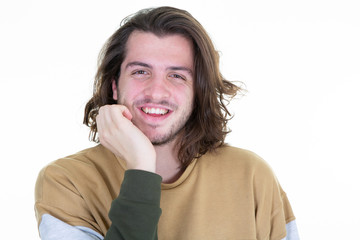 Obraz na płótnie Canvas Portrait of long haired handsome young man smiling against white background