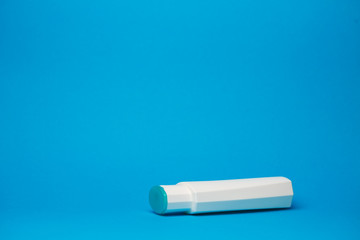 white bottle with cream, hair shampoo, shower gel, isolated blue background, human body beauty